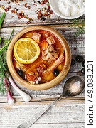 National Ukrainian soup Solyanka. Traditional solyanka with smoked meats in wooden plate. Стоковое фото, агентство Ingram Publishing / Фотобанк Лори