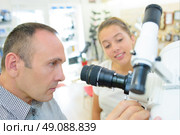 Man and young lady looking at telescope. Стоковое фото, агентство Ingram Publishing / Фотобанк Лори