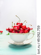 Cup full of ripe sweet cherries on light background, close up. Summer fruits and berries concept. Стоковое фото, агентство Ingram Publishing / Фотобанк Лори