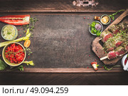 Meat skewers with vegetables and fresh flavoring, preparation for grill or BBQ on dark vintage background, top view, banner. Стоковое фото, агентство Ingram Publishing / Фотобанк Лори