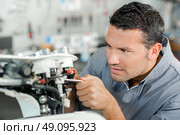 Mechanic tightening a bolt. Стоковое фото, агентство Ingram Publishing / Фотобанк Лори