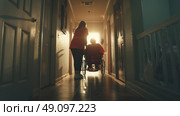 A caregiver pushes a person in a wheelchair towards a bright light at the end of a hallway. Стоковое AI-изображение, AI-художник Данила Большаков / Фотобанк Лори