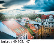 Red roofs of houses , and the overcast sky above the street in the old european town. Стоковое фото, агентство Ingram Publishing / Фотобанк Лори