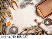 flour baking background with raw egg, rolling pin, wheat ear and rustic bake pan. Top view. Стоковое фото, агентство Ingram Publishing / Фотобанк Лори