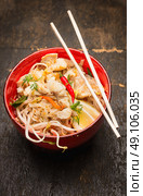 Asian noodles with chopstick, chicken and sprouts in red bowl, top view. Стоковое фото, агентство Ingram Publishing / Фотобанк Лори