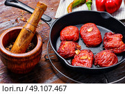 Sun-dried tomatoes in the pan. Spicy dish with sun-dried tomatoes and hot spices. Стоковое фото, агентство Ingram Publishing / Фотобанк Лори