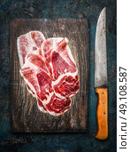 Slices of Iberico ham Cebo with kitchen knife on rustic wooden background, top view. Стоковое фото, агентство Ingram Publishing / Фотобанк Лори