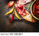 bruschetta or crostini with italian ham and antipasto on dark wooden background, close up. Стоковое фото, агентство Ingram Publishing / Фотобанк Лори