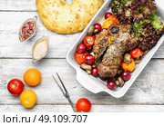 Meatloaf in vegetables and fruits. Meat knuckle of beef in the baking dish with tomatoes and plum sauce. Стоковое фото, агентство Ingram Publishing / Фотобанк Лори