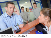 Man at reception desk, looking worried. Стоковое фото, агентство Ingram Publishing / Фотобанк Лори