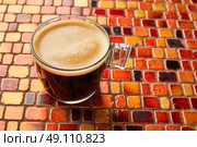 Coffee glass cup with cream on tiles red brown golden table. Стоковое фото, агентство Ingram Publishing / Фотобанк Лори