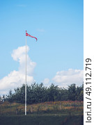 Pennant in danish colors on a lawn in a backyard. Стоковое фото, агентство Ingram Publishing / Фотобанк Лори