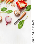 various vegetables ingredients for salad or healthy cooking with peeler on white wooden background, top view. Стоковое фото, агентство Ingram Publishing / Фотобанк Лори
