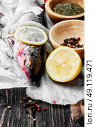 Seasoning for raw fish. Carcass raw fish on the kitchen table with spices. Стоковое фото, агентство Ingram Publishing / Фотобанк Лори