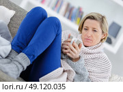 blonde sick woman laying on the couch with mug. Стоковое фото, агентство Ingram Publishing / Фотобанк Лори
