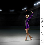 Young girl figure skater (on ice arena with spotlights ver) Стоковое фото, агентство Ingram Publishing / Фотобанк Лори
