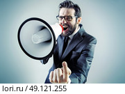 Agressive young businessman yelling over the megaphone. Стоковое фото, агентство Ingram Publishing / Фотобанк Лори