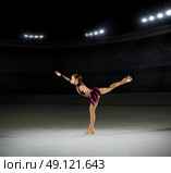 Young girl figure skater (on ice arena with spotlights ver) Стоковое фото, агентство Ingram Publishing / Фотобанк Лори