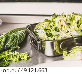 Cut Savoy cabbage in metal bowl on kitchen table. Стоковое фото, агентство Ingram Publishing / Фотобанк Лори