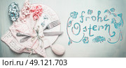 Easter table setting in pastel color with Frohe Ostern text in german. Стоковое фото, агентство Ingram Publishing / Фотобанк Лори