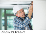 workman replacing guttering on exterior of house. Стоковое фото, агентство Ingram Publishing / Фотобанк Лори