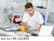 young engineer taking notes while developping new induction hobs. Стоковое фото, агентство Ingram Publishing / Фотобанк Лори