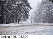 Snowfall and sleet on winter road. Ice snowy road. Winter snowstorm. Black ice and blizzard. Стоковое фото, агентство Ingram Publishing / Фотобанк Лори