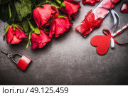 Valentines day background with pretty red roses bunch, heart, gift Candles, lock and key, top view, border. Стоковое фото, агентство Ingram Publishing / Фотобанк Лори