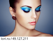 Portrait of young beautiful woman with blue makeup. Face Girl with earring close up. Fashion jewelry. Стоковое фото, агентство Ingram Publishing / Фотобанк Лори
