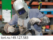 man with welding helmet welding steel. Стоковое фото, агентство Ingram Publishing / Фотобанк Лори