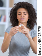 portrait of pretty woman applying bandage on wounded finger. Стоковое фото, агентство Ingram Publishing / Фотобанк Лори