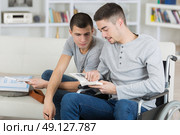 friend helping his disable friend in wheelchair to work. Стоковое фото, агентство Ingram Publishing / Фотобанк Лори