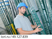 Man selecting shrink wrapped pack of poles. Стоковое фото, агентство Ingram Publishing / Фотобанк Лори