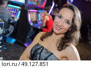 woman in casino next to a slot machine. Стоковое фото, агентство Ingram Publishing / Фотобанк Лори