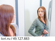 Lady trying on top in fitting room. Стоковое фото, агентство Ingram Publishing / Фотобанк Лори