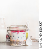 Glass jar with Healthy breakfast : oatmeal , Chia seeds, Goji berries, fresh berries and yogurt, front view. Стоковое фото, агентство Ingram Publishing / Фотобанк Лори