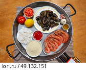 Seafood paella ingredients from Spain cuttlefish rice tomato shrimps. Стоковое фото, агентство Ingram Publishing / Фотобанк Лори