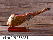 Iberian ham pata negra from Spain on wood background. Стоковое фото, агентство Ingram Publishing / Фотобанк Лори