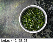 Wakame seaweed in water bowl on rustic background, top view, place for text. Стоковое фото, агентство Ingram Publishing / Фотобанк Лори