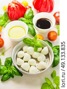 Mozzarella in bowl with basil leaves,oil,tomatoes and balsamic vinegar, italian food ingredients, close up. Стоковое фото, агентство Ingram Publishing / Фотобанк Лори