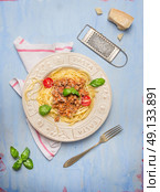 Spaghetti bolognese  with fork and old parmesan grater on blue wooden background, top view. Стоковое фото, агентство Ingram Publishing / Фотобанк Лори