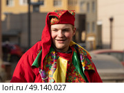 Молодой человек в народном шутовском костюме на улице. Редакционное фото, фотограф Пучков Андрей Александрович / Фотобанк Лори
