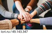 Diverse group of individuals gathering in a circle, unified as they put their hands together in a gesture of teamwork and unity. Стоковое AI-изображение, AI-художник Данила Большаков / Фотобанк Лори
