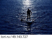 SUP Stand up Surf girl with paddle at sunset. Стоковое фото, агентство Ingram Publishing / Фотобанк Лори