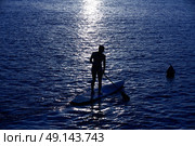 SUP Stand up Surf girl with paddle at sunset. Стоковое фото, агентство Ingram Publishing / Фотобанк Лори