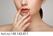 Beauty brunette woman with perfect makeup. Glamour girl. Red lips and nails. Skin care foundation. Beauty girls face isolated on light background. Fashion photo. Стоковое фото, агентство Ingram Publishing / Фотобанк Лори