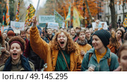 A diverse group of enthusiastic protesters march through a street lined with autumn trees, holding signs and banners while chanting and raising their fists. Стоковое AI-изображение, AI-художник Данила Большаков / Фотобанк Лори