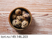 Quail eggs in a little bowl with nest shape on white wooden board. Стоковое фото, агентство Ingram Publishing / Фотобанк Лори