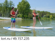 couple standing on paddle board. Стоковое фото, агентство Ingram Publishing / Фотобанк Лори