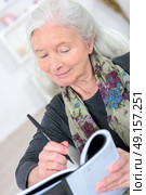 old woman with a crossword in the living room. Стоковое фото, агентство Ingram Publishing / Фотобанк Лори